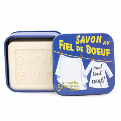 Fiel de bœuf : ce que c’est, comment l’utiliser et sur quelles taches | La Savonnerie de Nyons Savon de 100g au fiel de boeuf dans une boite en métal bleue illustrée de la collection de savons "Boites détachants"